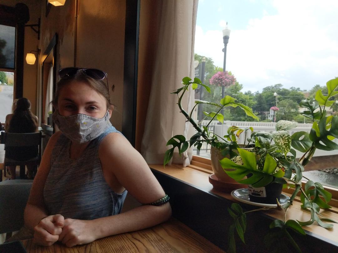 Laura next to a window with a plant